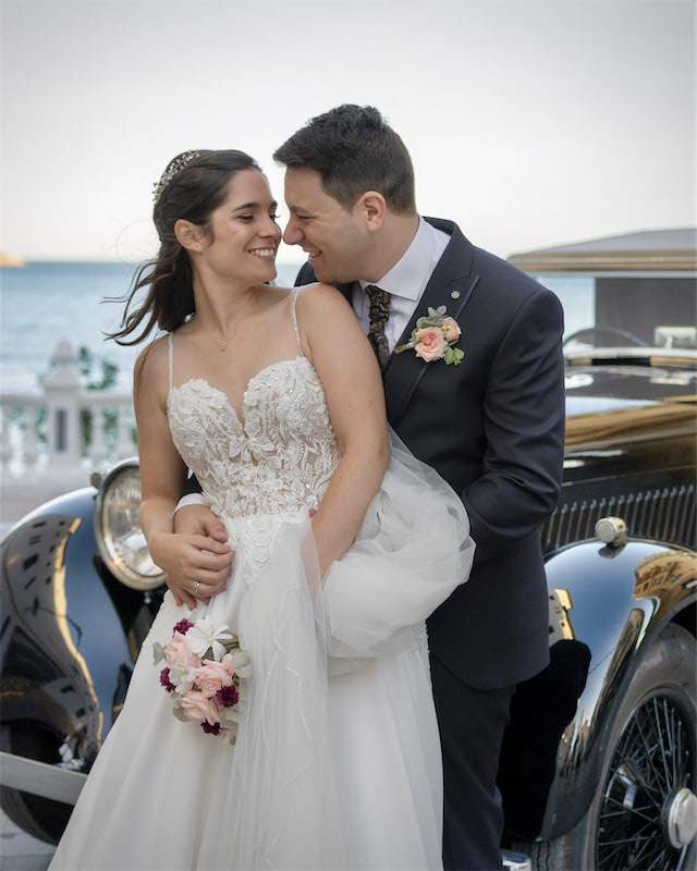 novios tonteando junto al coche clásico